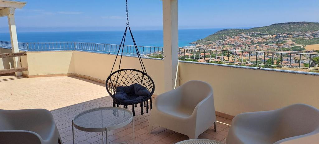 a balcony with chairs and a table and a swing at B&B L'alba Nel Golfo in Castelsardo