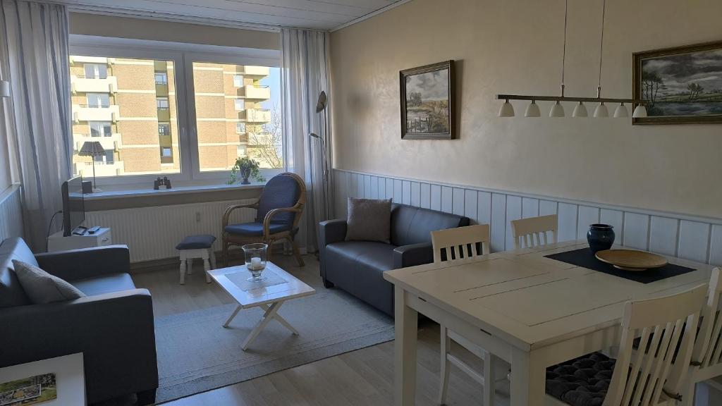a living room with a couch and a table at Haus Schildt, FeWo 6 in Duhnen