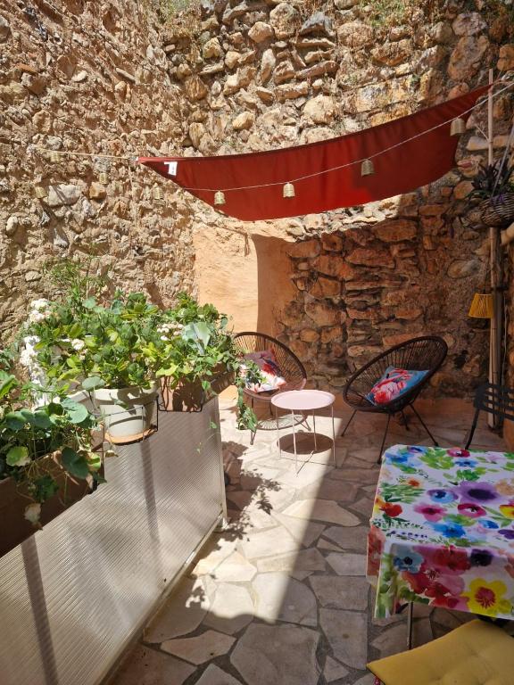 a patio with a table and chairs and a stone wall at maison de village in Thuir