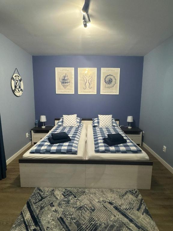 two beds in a bedroom with blue walls at Helski Zakątek in Hel