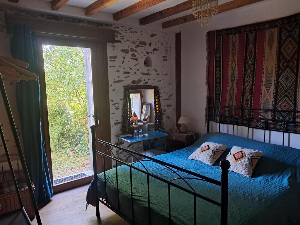 a bedroom with a bed and a mirror and a window at chambre à la campagne in Saint-Mathieu