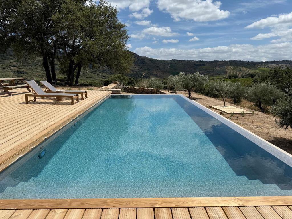 a swimming pool with a wooden deck and a swimming poolvisor at Casas da Vinha - Vineadouro Wine Hotel in Numão