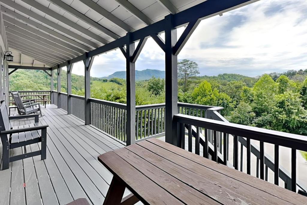 a porch with a wooden bench and a view of the mountains at Bluff Mountain Vista in Sevierville