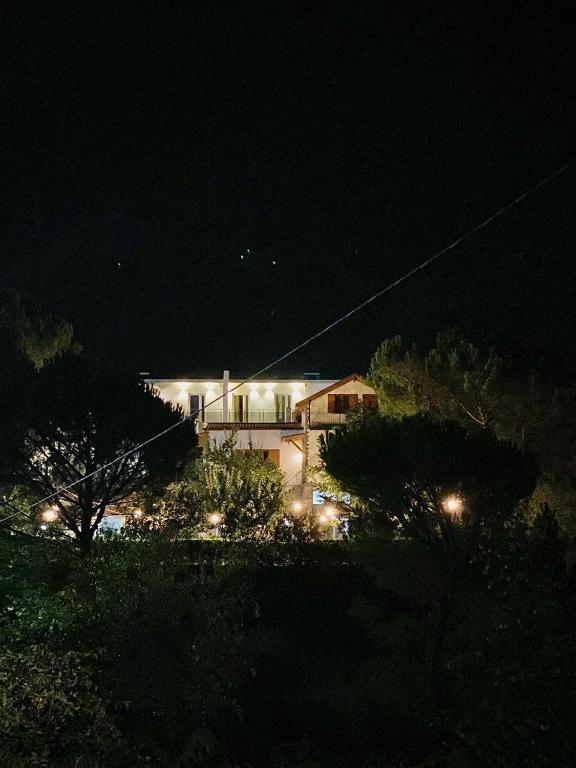 a house lit up at night with lights at Merly Hotel in Përmet