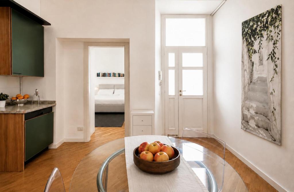 a kitchen with a bowl of fruit on a glass table at Vittorio Emanuele Apartment - Downtown Como in Como