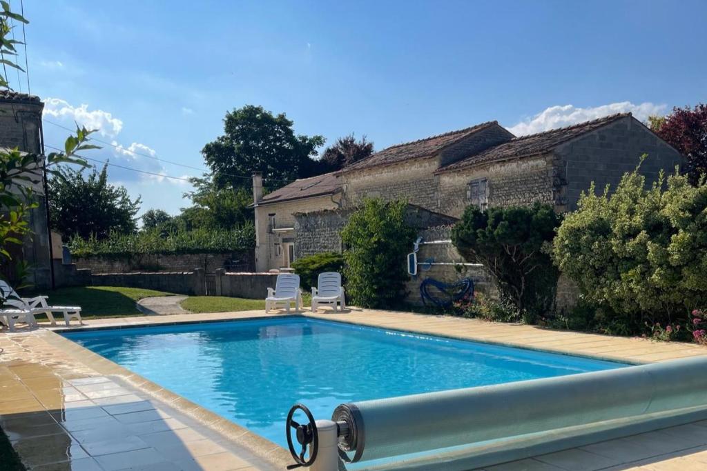 a swimming pool in front of a house at Rural French Gite Sleeps 8 with Pool and Parking in La Croix-Comtesse