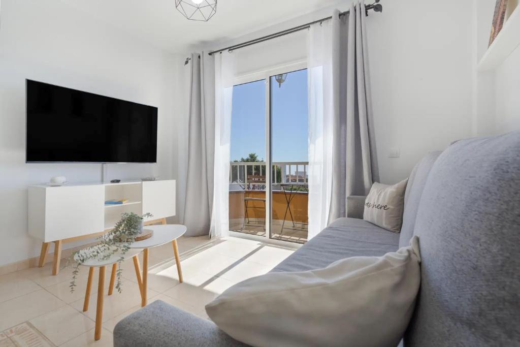 a living room with a couch and a tv and a window at Vista Montemar in San Miguel de Abona