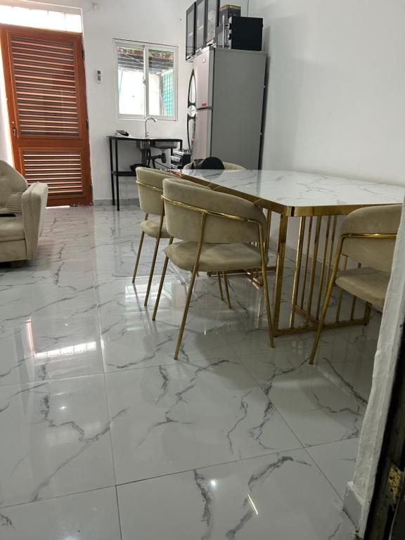 a kitchen with a table and chairs on a tile floor at T1 centro da cidade cif in Luanda