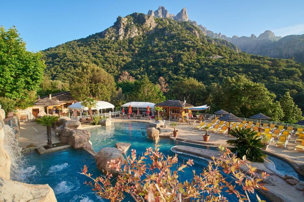 a swimming pool with a mountain in the background at Résidence A Barcella in Porto Ota