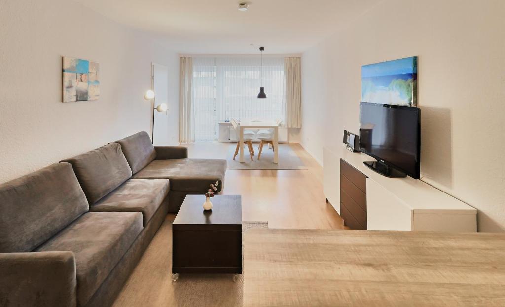 a living room with a couch and a flat screen tv at Düne, App 9 in Duhnen