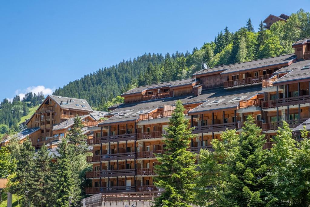 a large building with trees in front of a mountain at Résidence Pierre & Vacances Les Ravines in Méribel