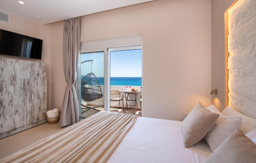 a bedroom with a bed and a view of the ocean at Petra Studios in Palaiochora