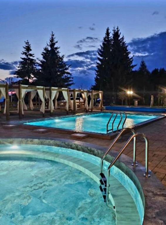 a swimming pool at a resort at night at Harmony, Residence Hill A85 in Kopaonik