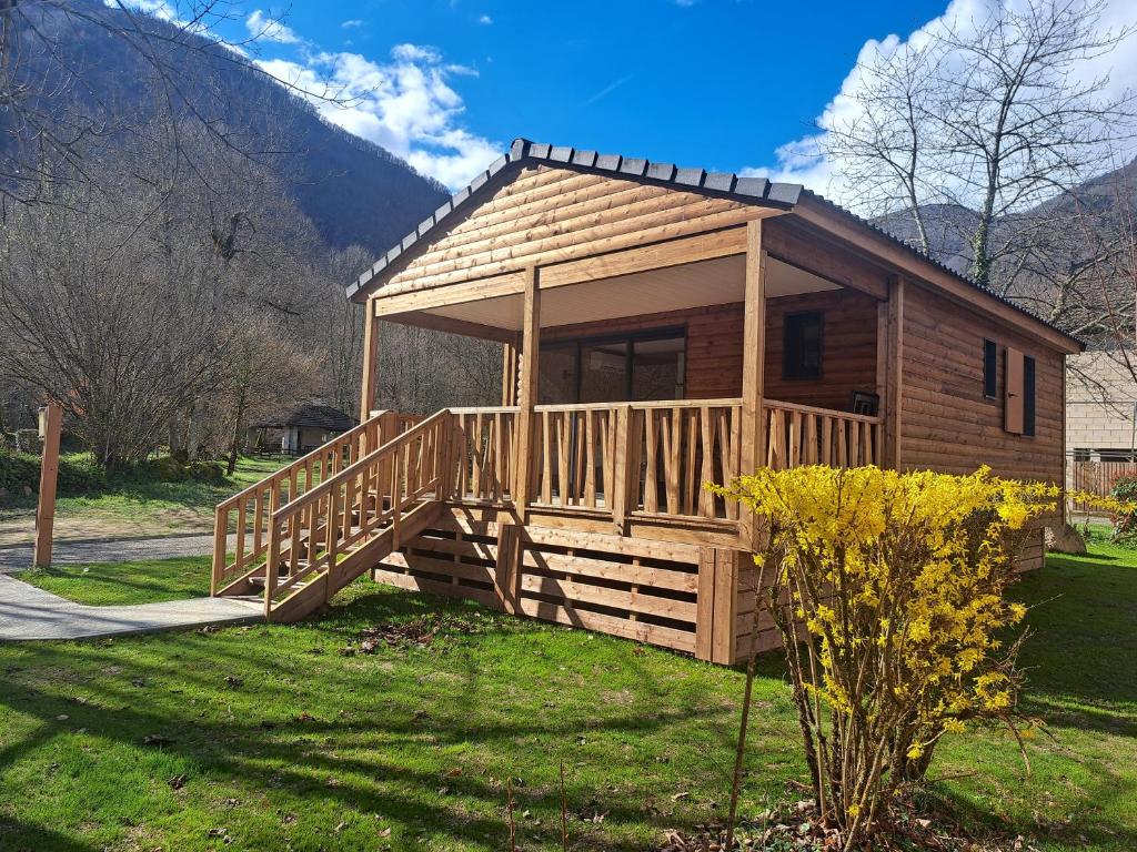 a log cabin with a large porch and a deck at Le Pas de L'Ours in Aston