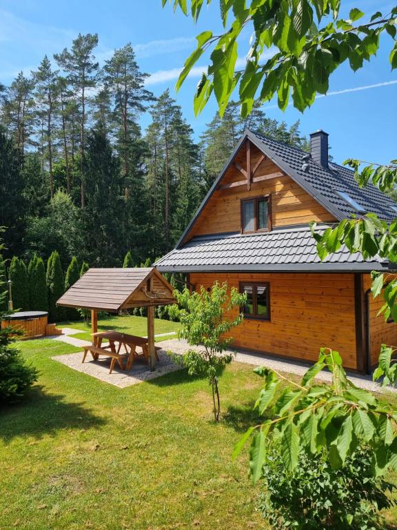 a wooden house with a picnic table in the yard at Gajówka nad Serwami in Mołowiste