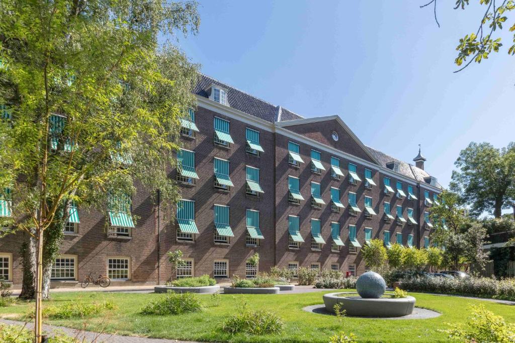 a large brick building with a statue in front of it at Wittenberg by Cove in Amsterdam