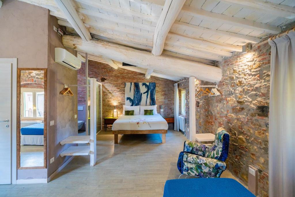 a bedroom with a bed and a brick wall at Inside the Wall in Lucca