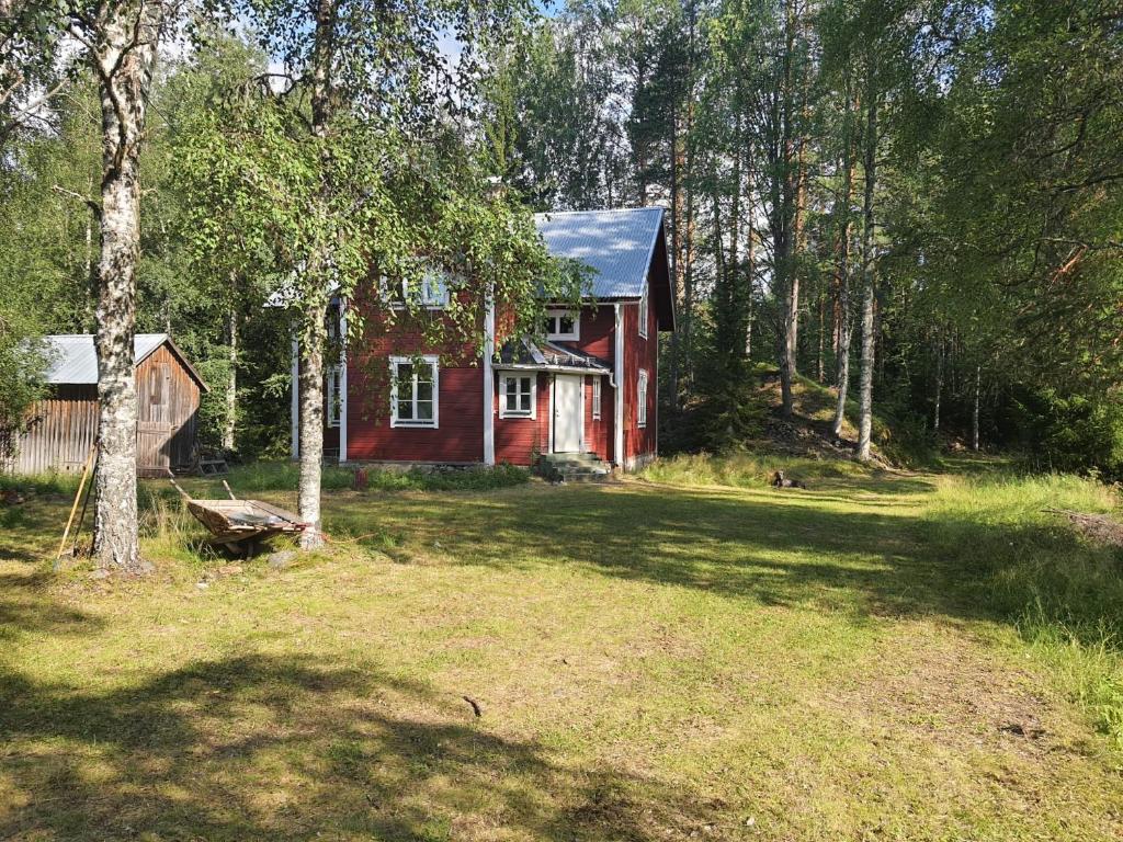 a red house in the middle of a forest at Beautiful detached house in Sörsjön