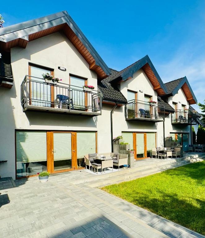 a house with two balconies and a patio at Domki Apartamentowe 3Fale in Władysławowo
