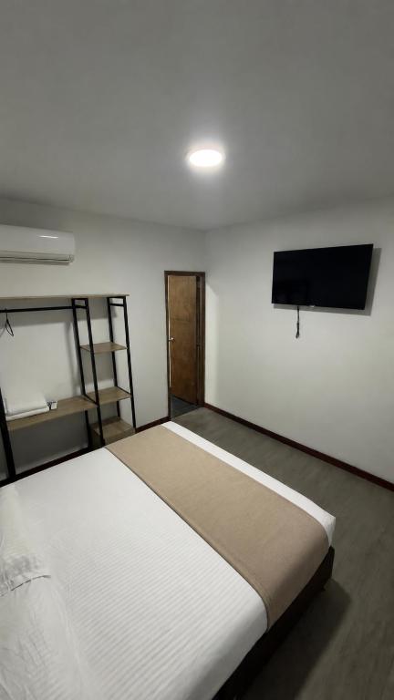 a bedroom with a bed and a flat screen tv at Hotel Gallery By 70 in Medellín