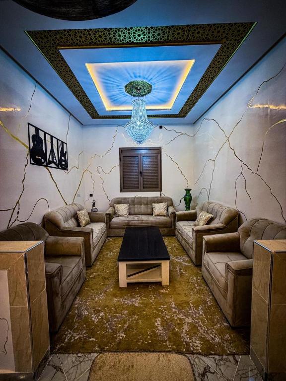 a living room with couches and a table in the middle at Merzouga Desert Apartment in Merzouga