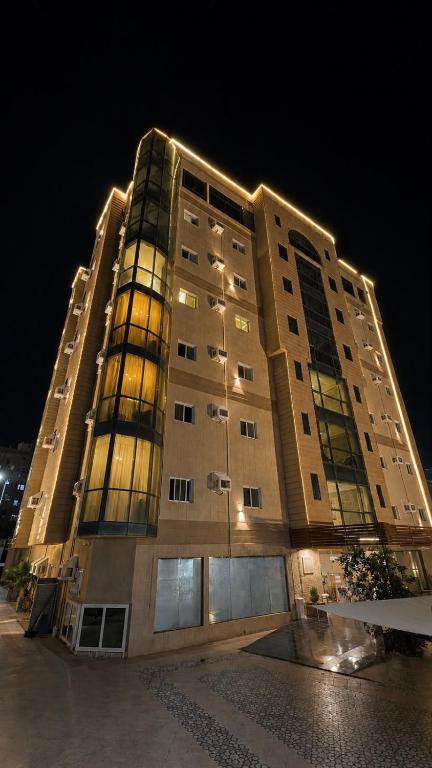 a large tall building with lights on it at night at ترند سويتس - TREND Suites in Al Baha