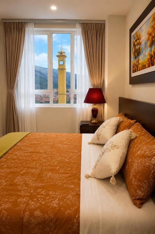 a bedroom with a bed with a clock tower in the window at Chanka Suites in Talavera