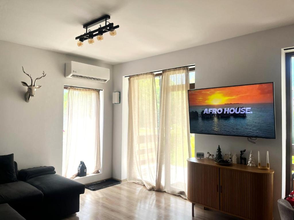 a living room with a couch and a flat screen tv at Mountain Place to Remember - River & Barbecue in Buşteni