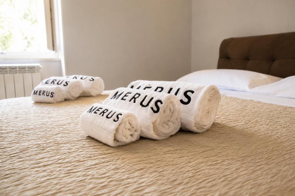 a pile of towels with the words news written on them on a bed at Merus in Faicchio