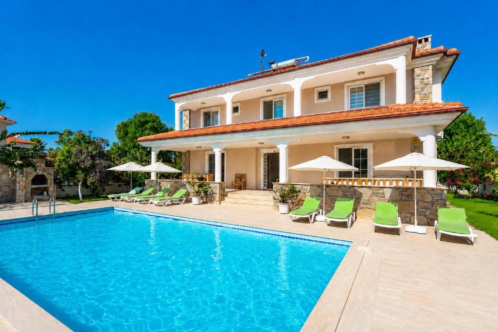 a villa with a swimming pool in front of a house at Villa Kubra in Dalyan