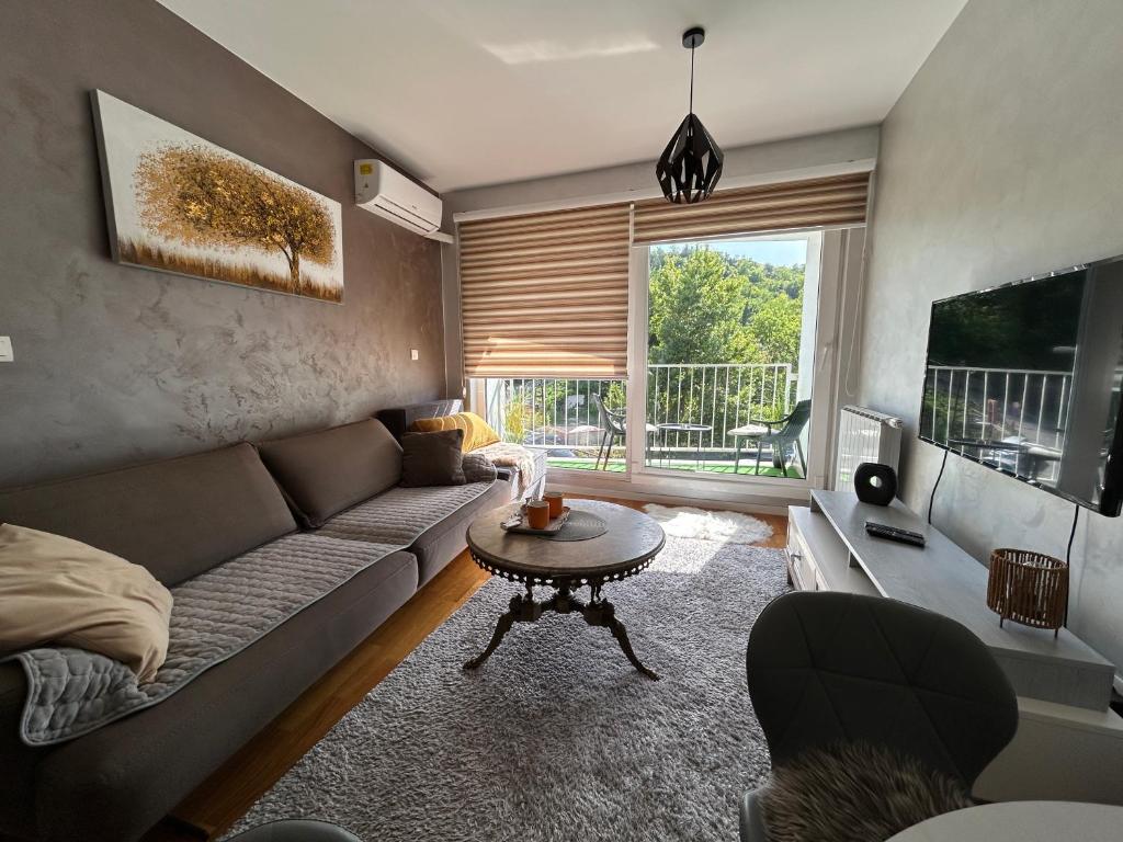 a living room with a couch and a table at CENTRAL POINT APARTMENT - City centar Zenica- in Zenica