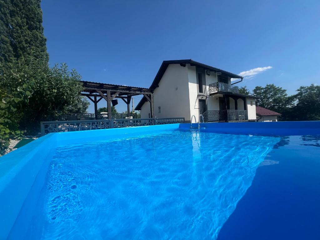a villa with a swimming pool in front of a house at Holiday Home Nirvana in Gornji Mihaljevec