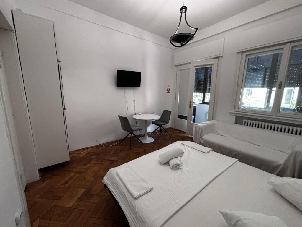 biały pokój z łóżkiem i stołem w obiekcie Iancu Apartments w Bukareszcie