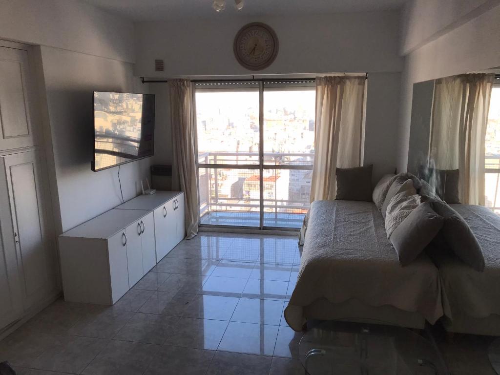 a bedroom with a bed and a large window at Corrientes Center in Buenos Aires