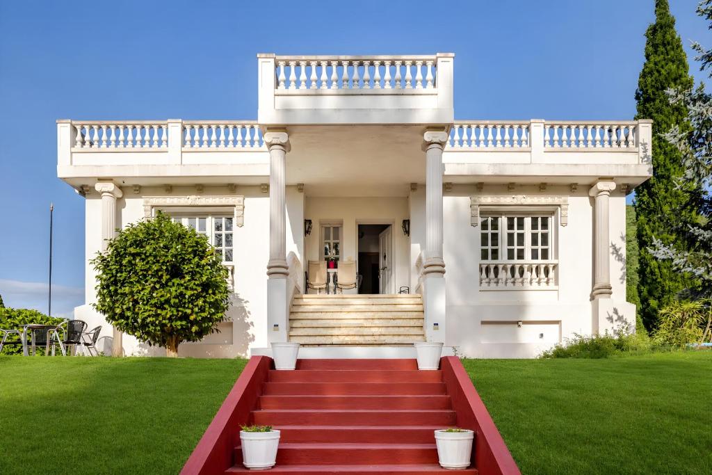 a large white house with a red staircase at Villa Horta in Horta
