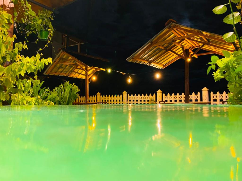 a swimming pool at night with an umbrella at Nature Rock Ella in Ella