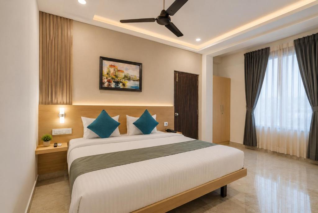 a bedroom with a large bed with blue pillows at Hotel Elite kukatpally Near Nexus Mall in Hyderabad