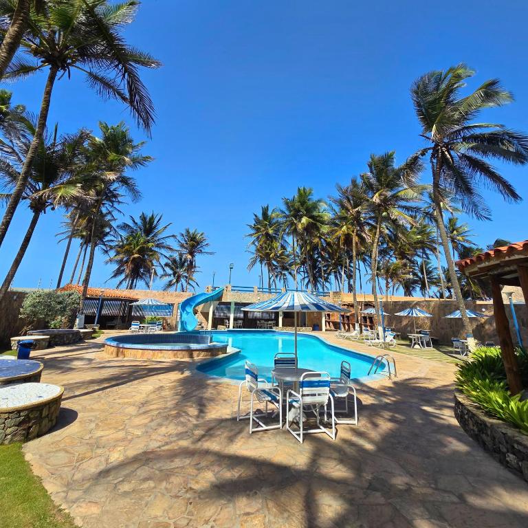 a swimming pool with chairs and palm trees at Tucacas, Frente al Mar, Piscina y Playa Privada in Tucacas