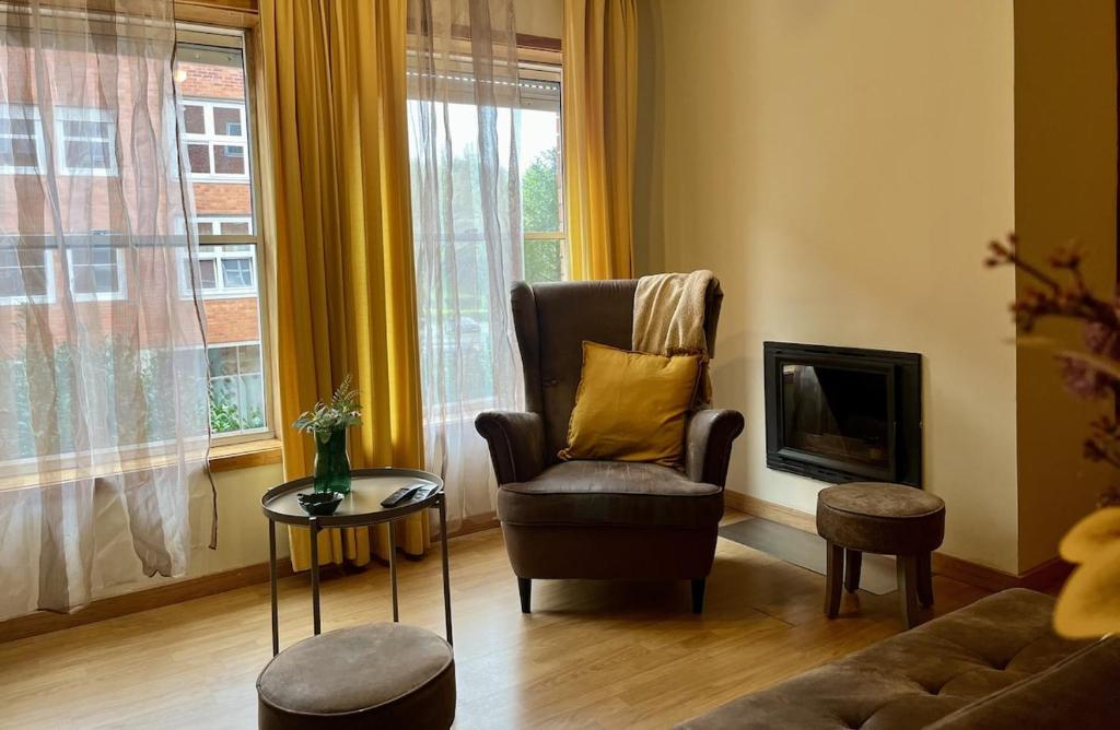 a living room with a chair and a fireplace at Porto Nest in Senhora da Hora