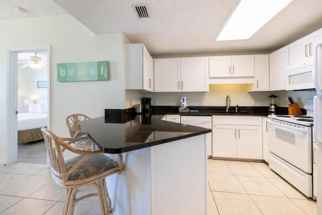 a kitchen with white cabinets and a black counter top at Phoenix X 811 in Orange Beach