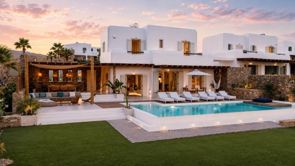a villa with a swimming pool in front of a house at Villa RED VENUS in Kalafatis