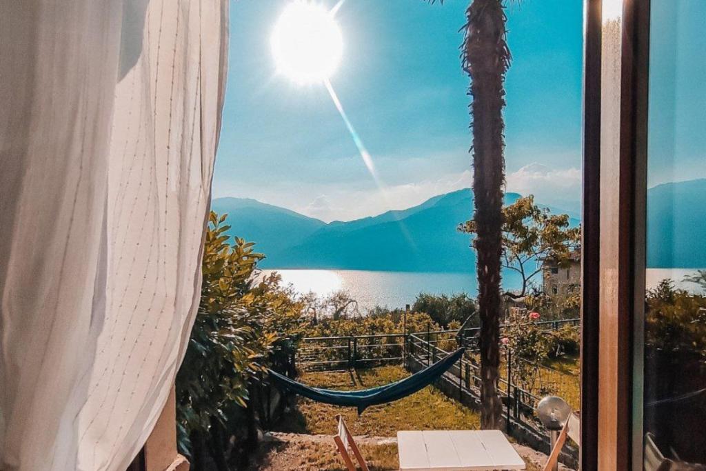 a window with a hammock and a view of a lake at Studio with private garden by GardaDoma in Brenzone sul Garda