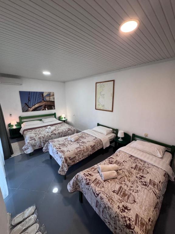 a bedroom with three beds in a room at Robinson Hotel in Zatoka