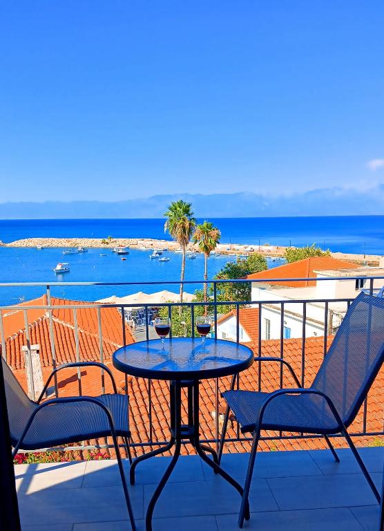 a table and chairs on a balcony with a view of the ocean at ANGIRA - Koroni Apartments in Koroni