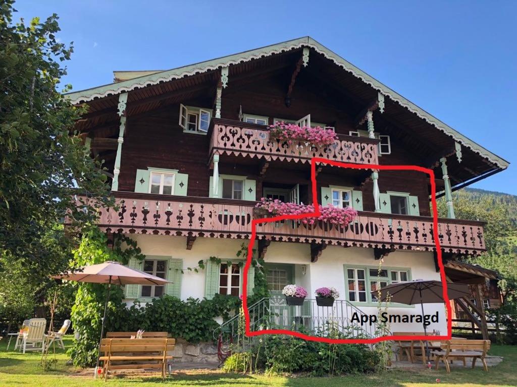 a large house with a balcony with flowers on it at Villa Zeppelin - App Smaragd in Bramberg am Wildkogel