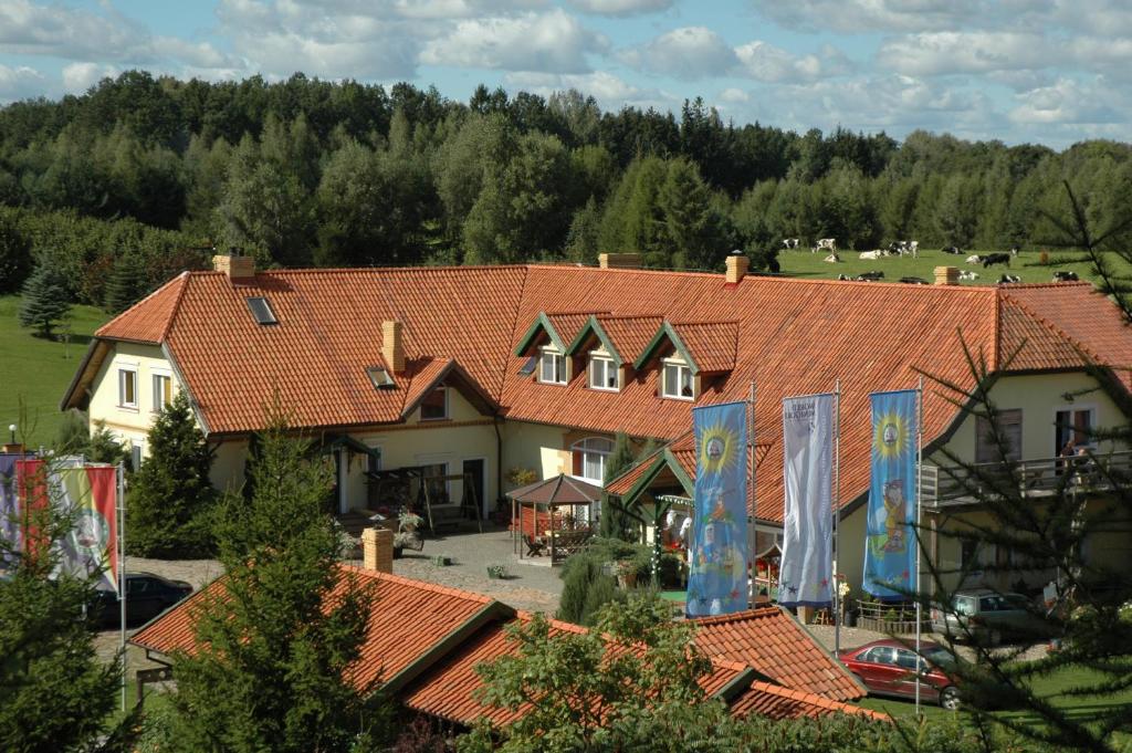 un gran edificio con techos de baldosas rojas y un patio en Majątek Giże Marczak en Olecko