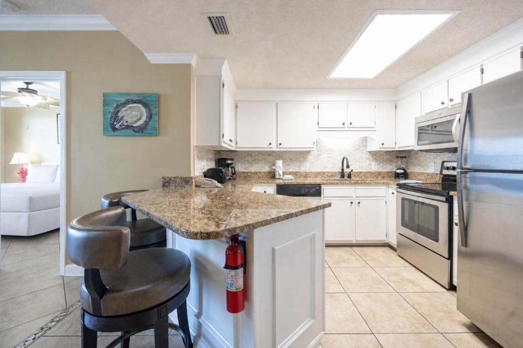 a kitchen with white cabinets and a granite counter top at Phoenix X 911 in Orange Beach