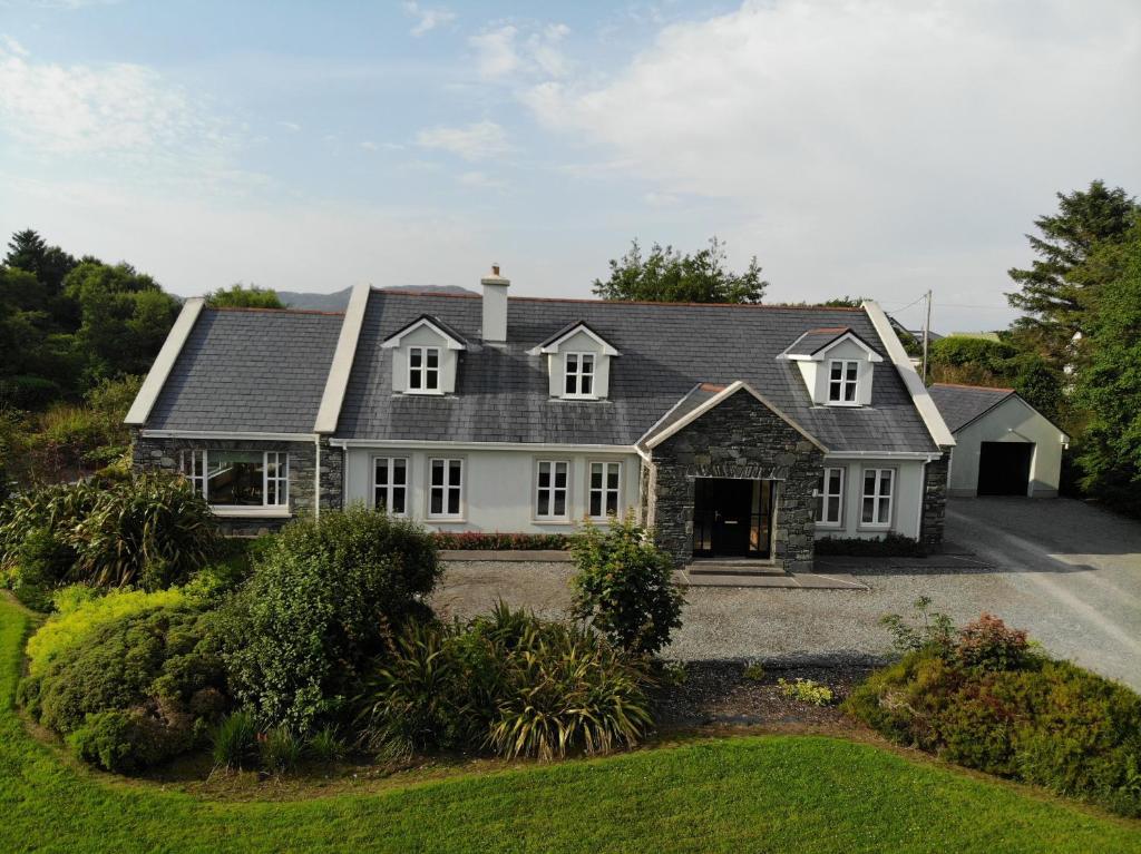 a white house with a gray roof at Ballinakill Lodge in Moyard