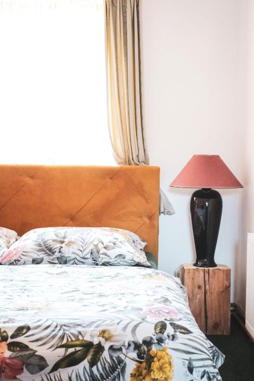 a bedroom with a bed and a lamp on a table at Penzion Prezident in Soběraz