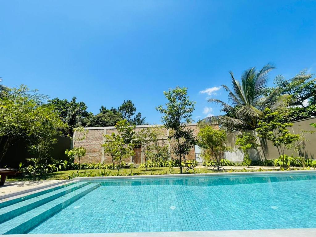 a swimming pool in front of a building at Dhyana Beach Villa in Ambalangoda